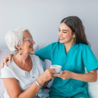 happy-senior-woman-talking-with-friendly-nurse-geriatric-ward (1)